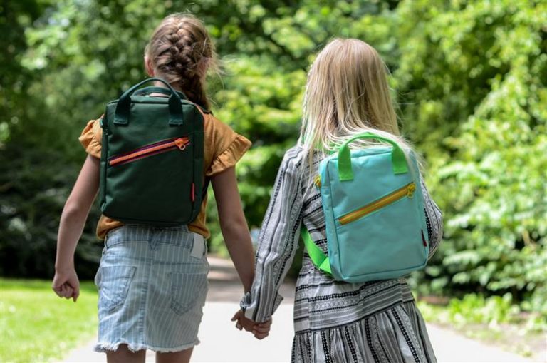 Home Kind op een kinderfiets met zijwieltjes in verschillende kleuren